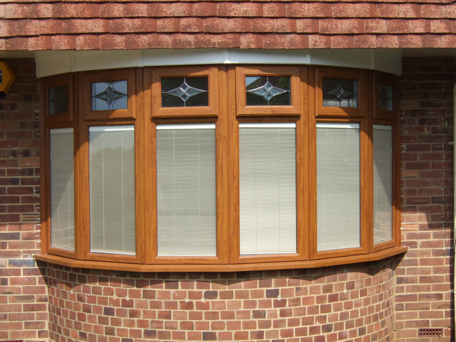 Red brick exterior with wooden window frames and white blinds.