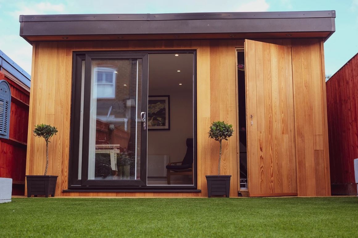 Brick house renovation with glass door installation and workers.