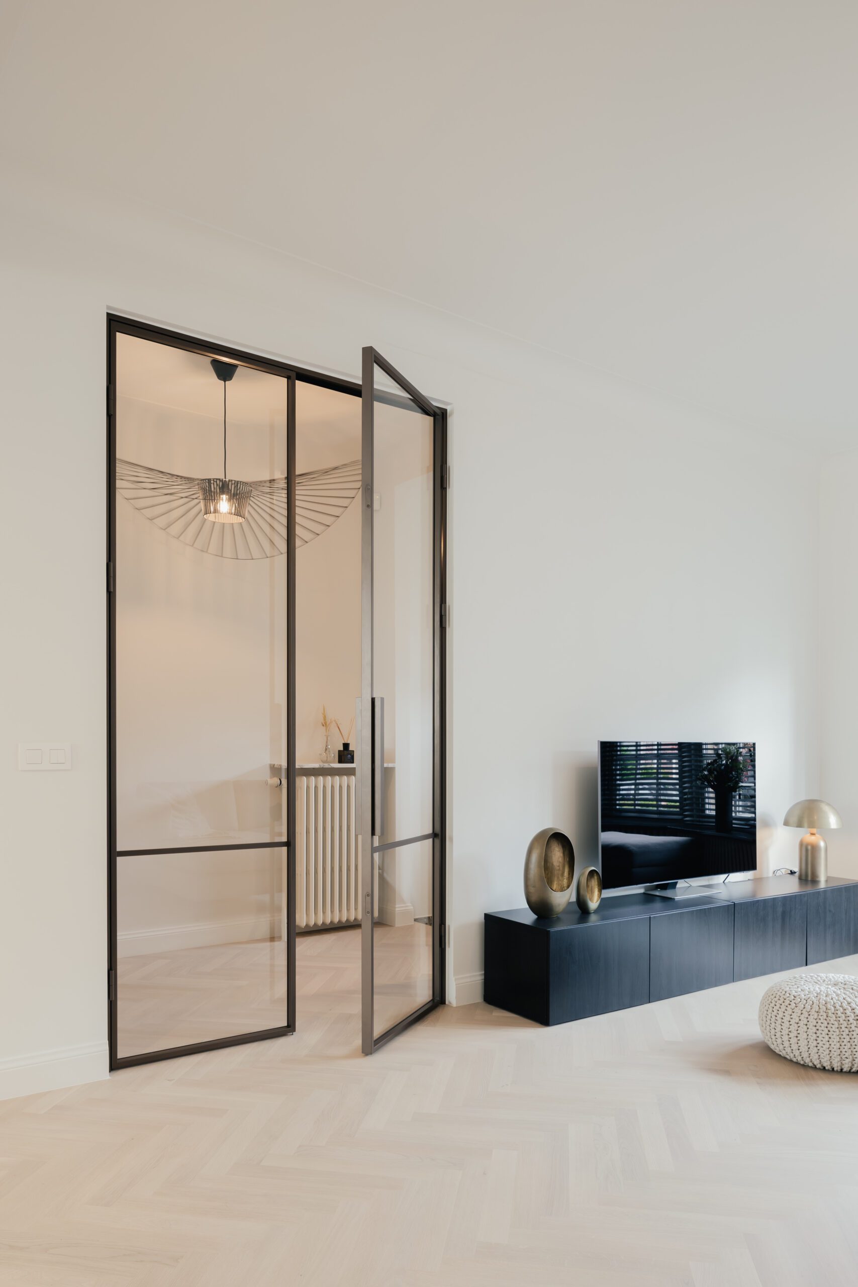 Open steel-framed glass door in a modern room.