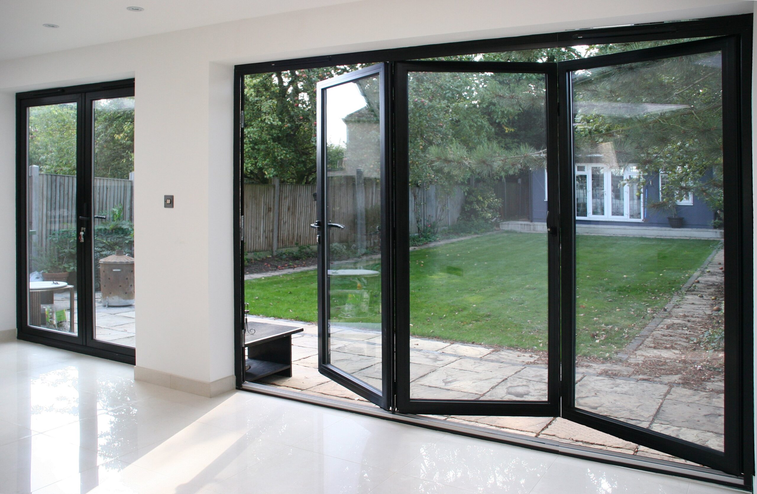 Stylish modern house interior, large glass doors opening to a lush garden.