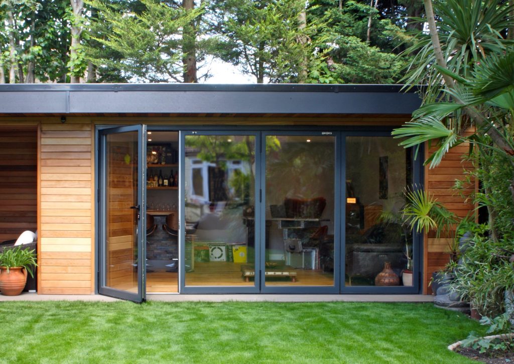 Conservatory with skylights and dining space featuring wooden table.