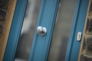 Silver door handle on a blue front door.
