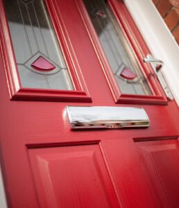 Red front door with a chrome mailbox.