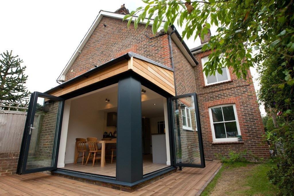 Sleek kitchen, dark cabinets, island, bar stools, natural light, modern design.