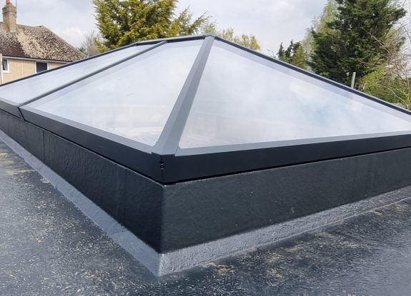 Andy Bache 1.5 Black-framed skylight with transparent panels on pitched roof.