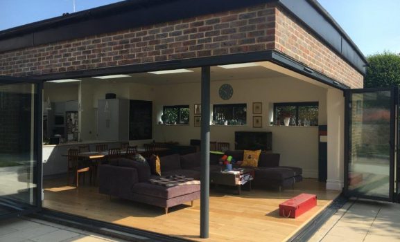 Modern extension with glass walls and a living room interior.