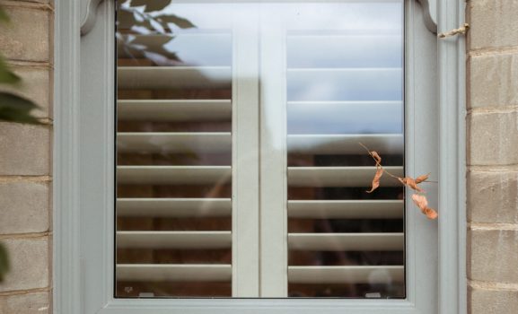 Double hung Sash Window 4 A close-up shot of a light grey sash window with white shutters