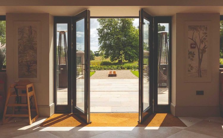 Open French doors revealing a sunlit garden view.