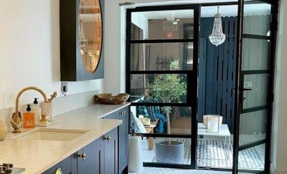 Heritage Aluminium Doors 1 Stylish balcony with glass doors and tiled outdoor flooring.