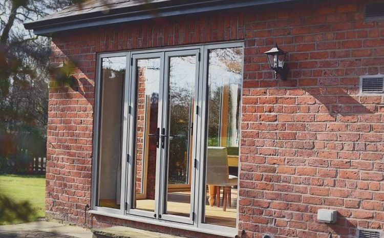 Brick house rear elevation with grey folding patio doors”