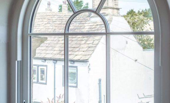 Classic white sash window on a brick house, preserving traditional style with modern benefits.