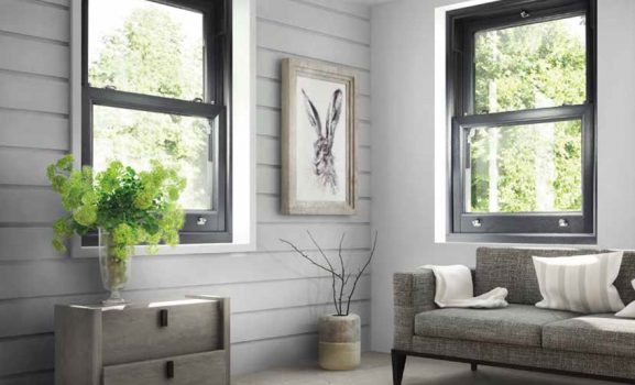 Cozy modern living room with sofa, plants, and large windows.