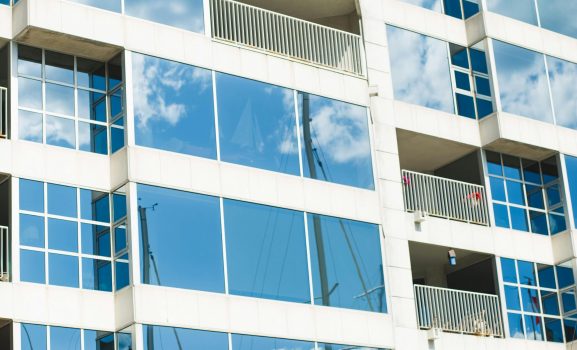 Reflective glass building facade with blue sky.