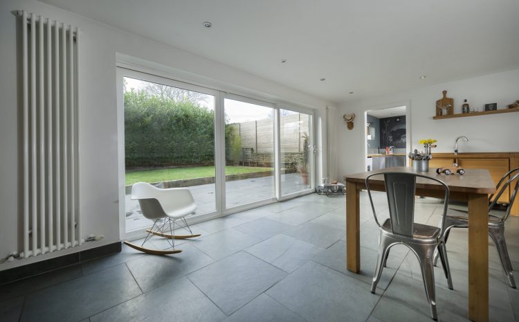 Large glass doors connecting indoor living area to backyard garden.