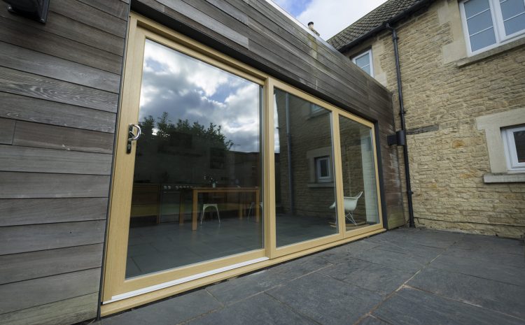 Outdoor patio with black container around wooden door.
